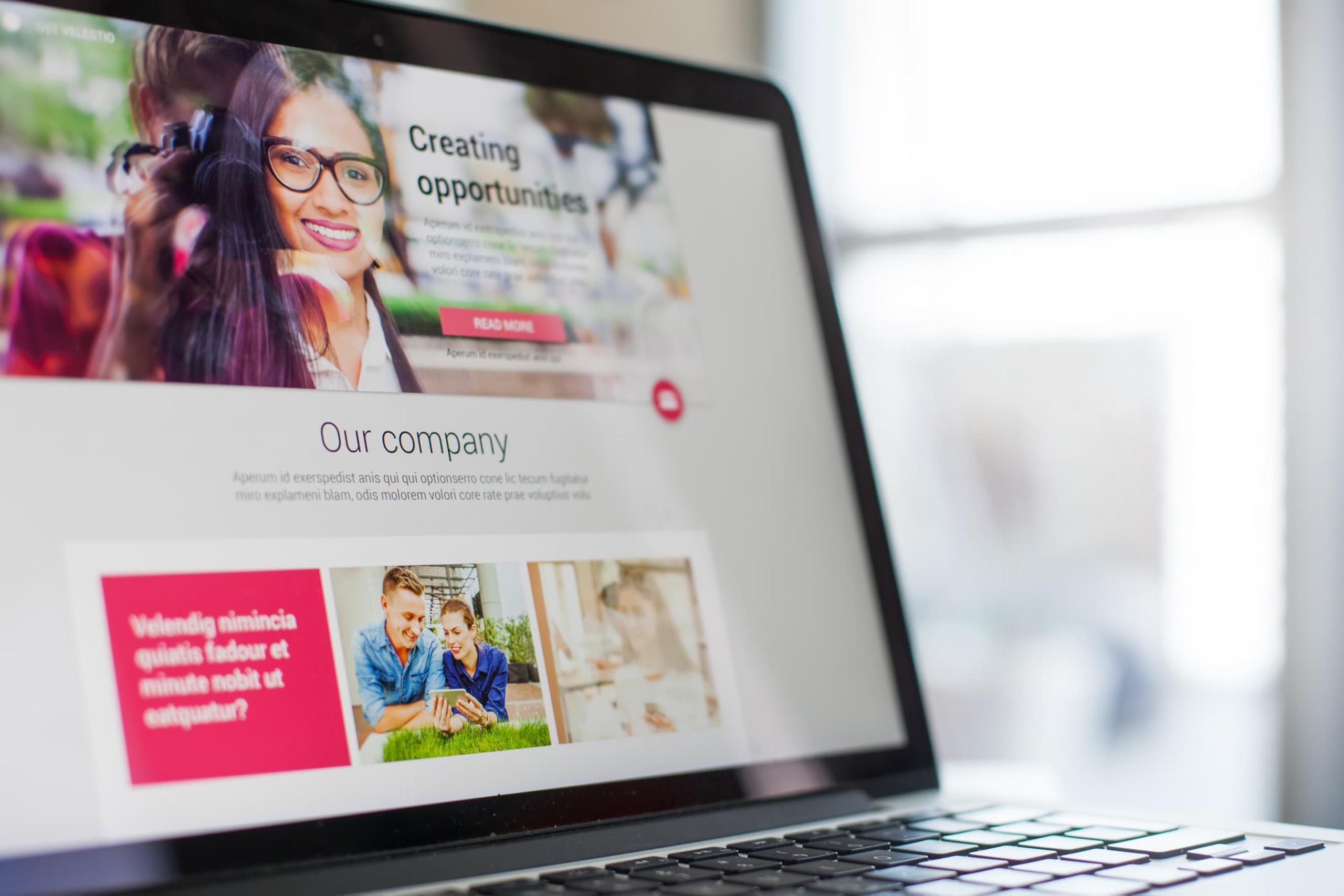 Una pantalla de computadora portátil que muestra la página de inicio del sitio web de una empresa, donde una mujer sonriente con anteojos representa una marca inteligente, mientras que debajo, una pareja que sostiene alegremente una cámara refleja la experiencia perfecta del comercio electrónico.